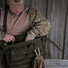 DÖRR ProTac Waffentasche oliv im Outdoor-Einsatz, Person beim Verstauen von Ausrüstung in die taktische Kurzwaffentasche 